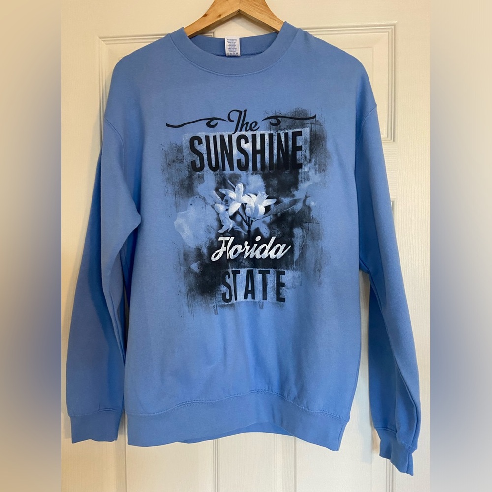 Ladies medium blue sweatshirt , “Florida The Sunshine State”with flowers.